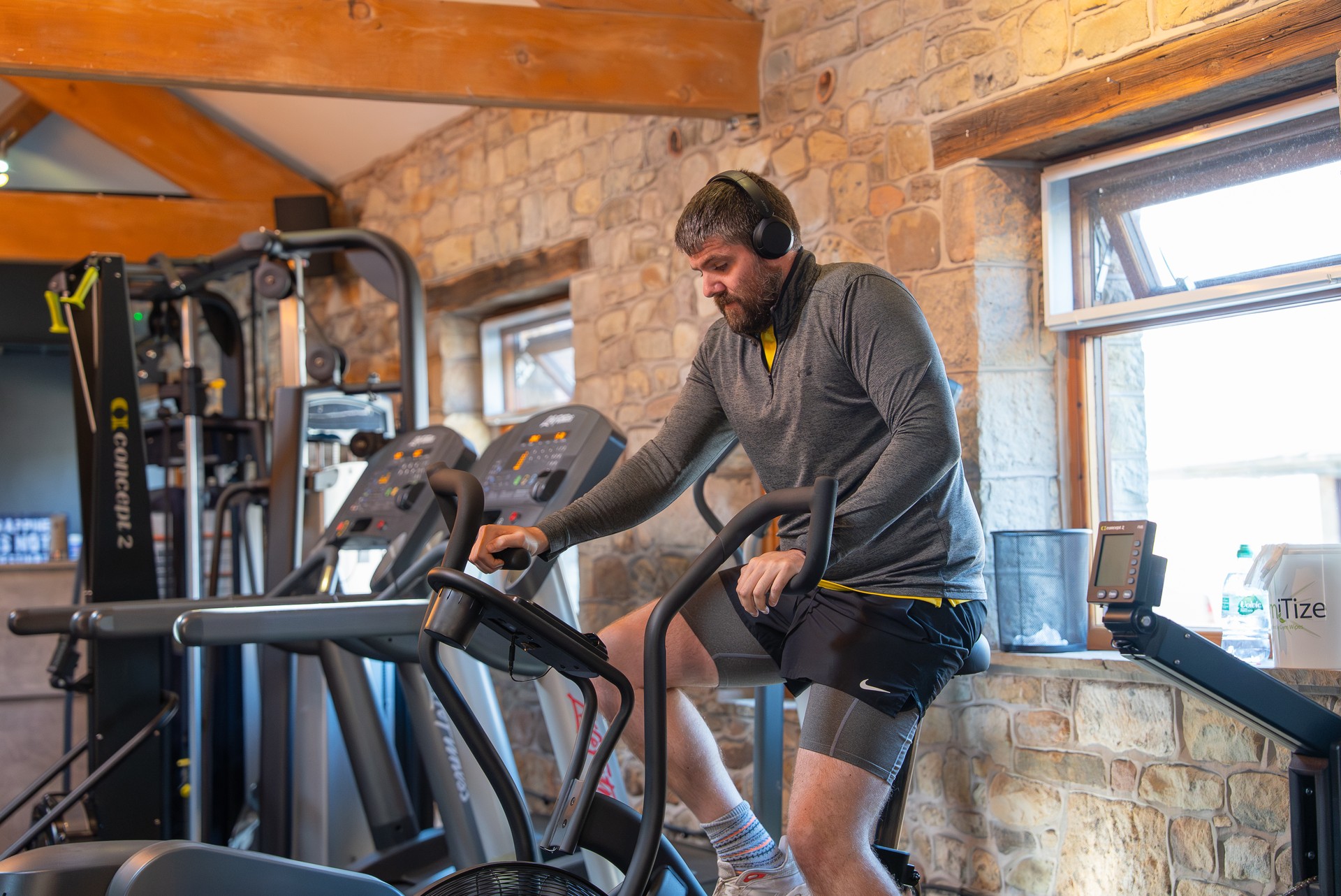 A member training alone on the air bike in the cardio corner