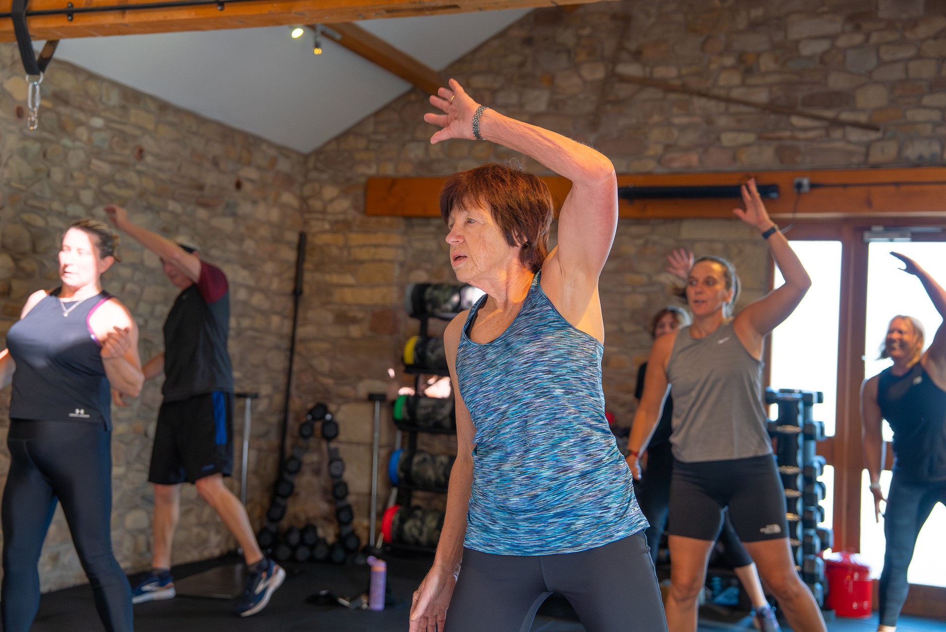 A mixed-age group class stretching together in the barn